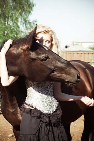 outdoor portrait of young beautiful woman with horseの写真素材
