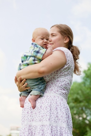 young woman with the small child against the blue skyの写真素材