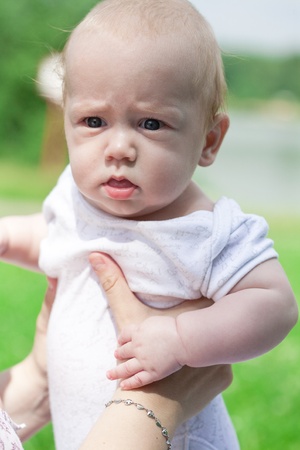 Summer portrait of beautiful baby on the lawnの写真素材