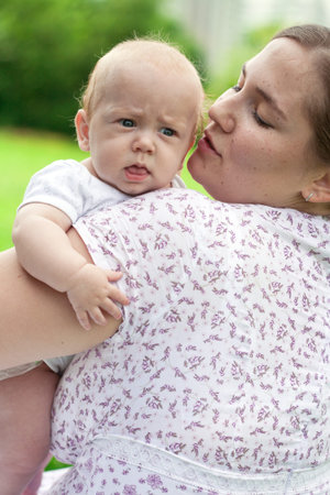 Young mum walks with the child in city park