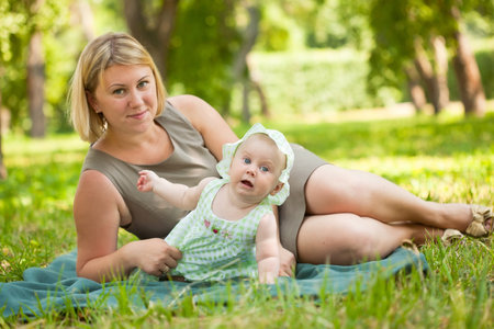 Young mum walks with the child in city park