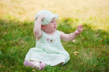 Summer portrait of beautiful baby on the lawnの写真素材