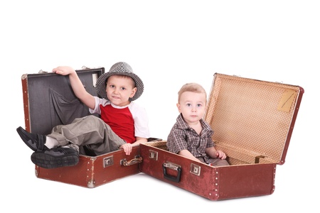 Two brothers sit in old suitcasesの写真素材