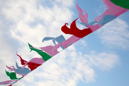 Tape with multi-colored tags against the blue skyの写真素材