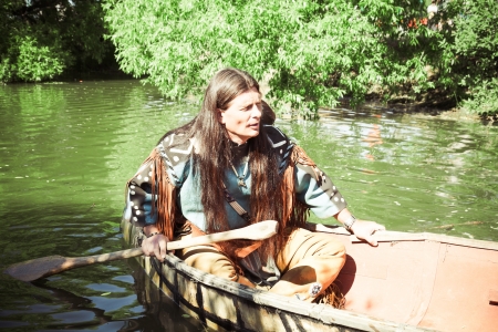 North American Indian floats down the river on a canoe の写真素材