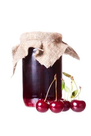 Cherry jam glass jar reflected on white background の写真素材