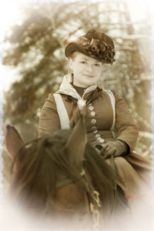 Eleganny woman in riding habit sits astride a bay Arab racerの写真素材