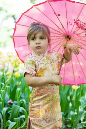 little girl in a kimono with a pink umbrellaの写真素材