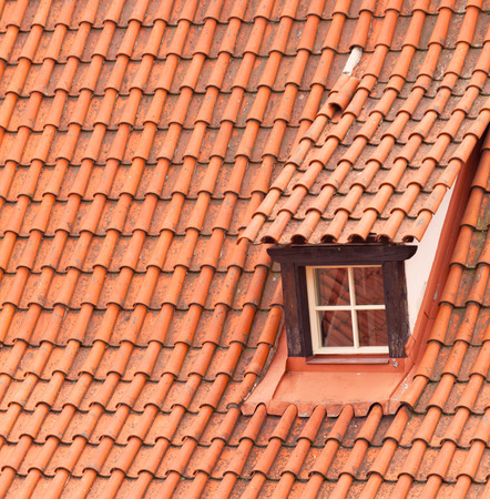 Tile roof with a window as a backgroundの写真素材