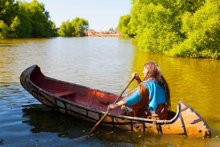 North American Indian floats down the river on a canoeの写真素材