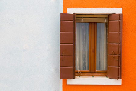 Orange-white wall and window close up, a house wall fragment on Burano's island, Veniceの写真素材