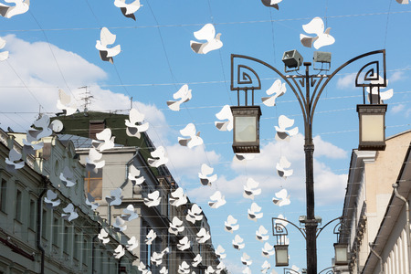 Street decorated with lots of white paper birdsの写真素材