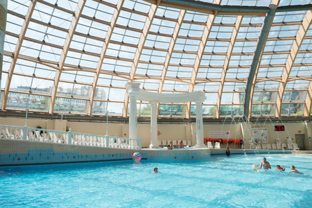 RUSSIA, MOSCOW - JUNE 15, 2016: Adults and children resting in the water park, swimming in the pool with artificial wavesのeditorial素材