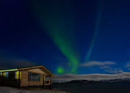 Landscape with a wooden house and auroraの写真素材