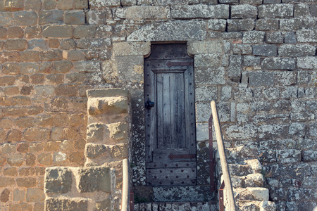 Old wooden door in a stone wallの写真素材