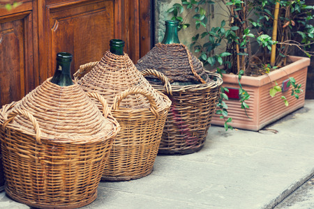 Vintage large wine bottles stand on the streetの写真素材