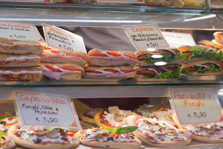 Varied sandwiches and pizza on the counter of a street cafeの写真素材