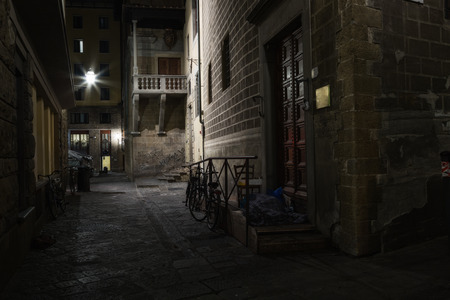 The homeless man sleeps on the porch, hiding behind a blanket. Florence, Italy.の写真素材