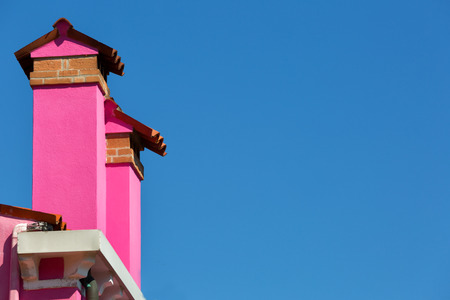 Two pink chimneys against the blue skyの写真素材