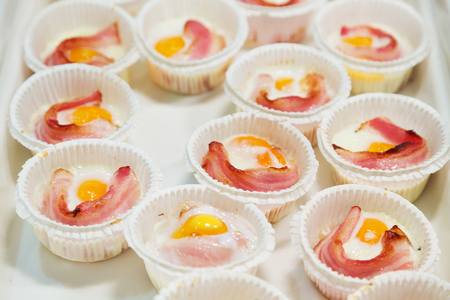 Portions of scrambled eggs and bacon for breakfastの写真素材