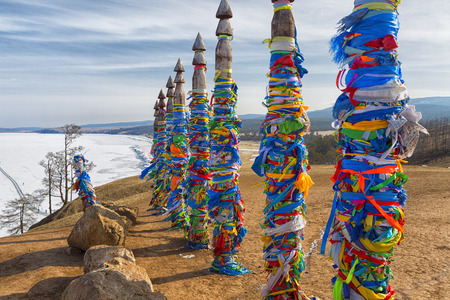 Wooden ritual pillars with colorful ribbons on cape Burkhan, Lake Baikal, Olkhon, Russiaの写真素材