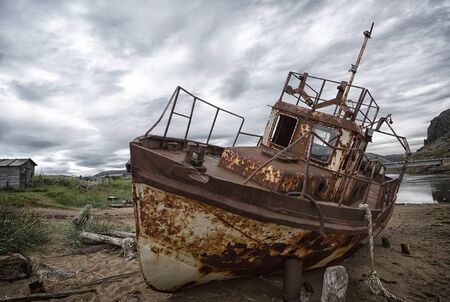 Old rusty fishing boats in summer cloudy day. Teriberka. Russiaの写真素材