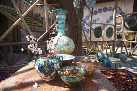 Uzbek traditional dishes, a branch of flowering almonds and a dish with dried apricots in the yardの写真素材