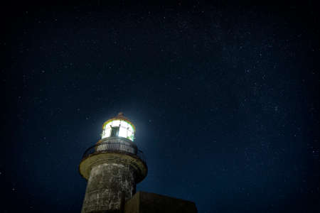 Working lighthouse and starry skyの写真素材