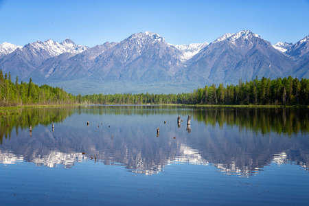 Landscape with mountains reflecting in the water on summer day. Buryatia, Tunkinskaya valley, Russiaの写真素材