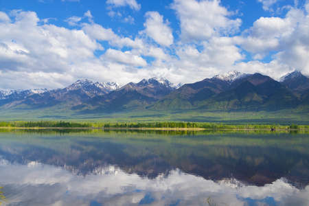 Landscape with mountains reflecting in the water on summer day. Buryatia, Tunkinskaya valleyの写真素材