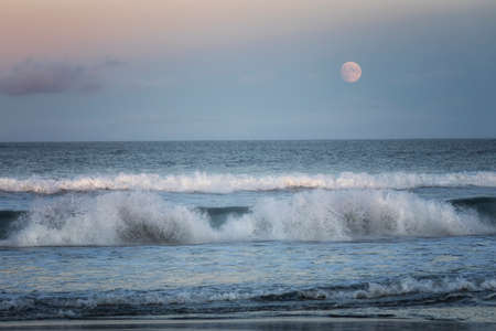 Seascape with moon at sunsetの写真素材