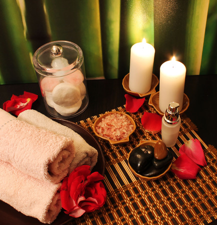 Spa still-life with candles, sea salt, towel, massage stones and rose petalsの写真素材