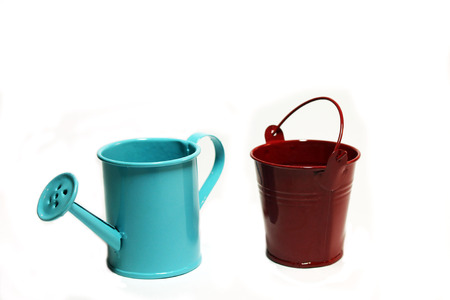 Blue garden handshower and a red bucket on a white backgroundの写真素材