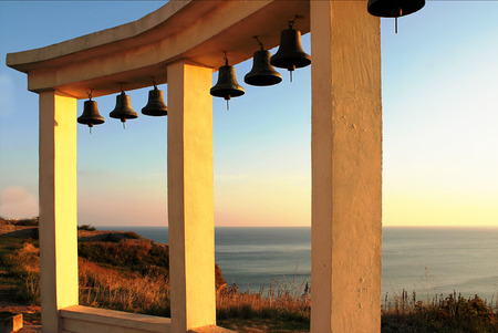 Arch with bells on the sky background and sea landscapeの写真素材
