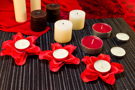 Still life of candles of different shapes on a black and red backgroundの写真素材