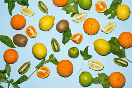 Background of lemons tangerines lime and kiwi on blueの写真素材