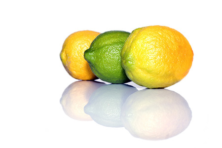 Three lemons yellow and green with reflection on a white isolated backgroundの写真素材