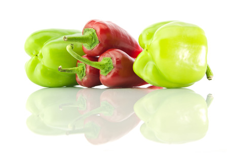 Green bell peppers, red peppers and it's reflection on a white isolated  backgroundの写真素材