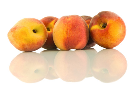 Peaches laid a bunch and it's reflection on a white isolated backgroundの写真素材