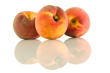 Three ripe peach and it's reflection on a white isolated backgroundの写真素材