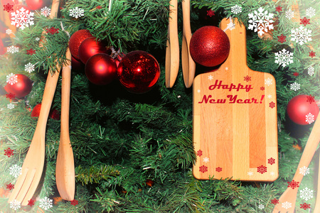 New Years still life of a cutting board and wooden spoons on a background of decorated Christmas treeの写真素材
