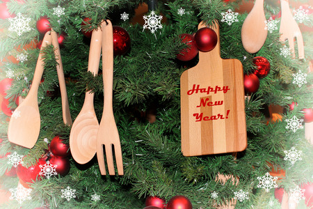 New Years still life of a cutting board and wooden spoons on a background of decorated Christmas treeの写真素材