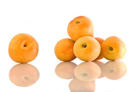 Apricots handful with reflection on white isolated backgroundの写真素材
