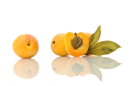 Apricots with leaf and their reflection on white  isolated backgroundの写真素材
