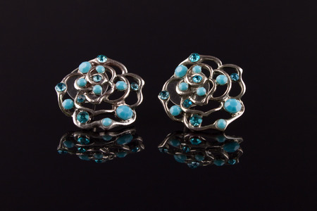 Bijouterie on a black isolated background with reflection. Earrings with blue stonesの写真素材