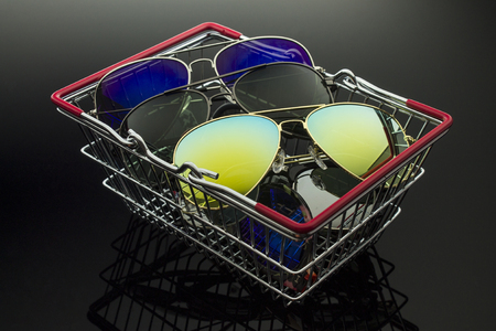 Sunglasses various models and colors stacked in a shopping basketの写真素材