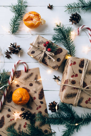 Christmas gifts, lollipop, tangerine on white wooden backgroundの写真素材