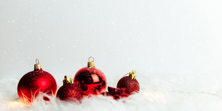 Red christmas balls on white background with feathersの写真素材