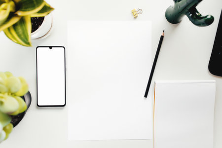 Smartphone on white table, work from home, office stuffの写真素材