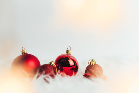Red christmas balls on white background with feathersの写真素材